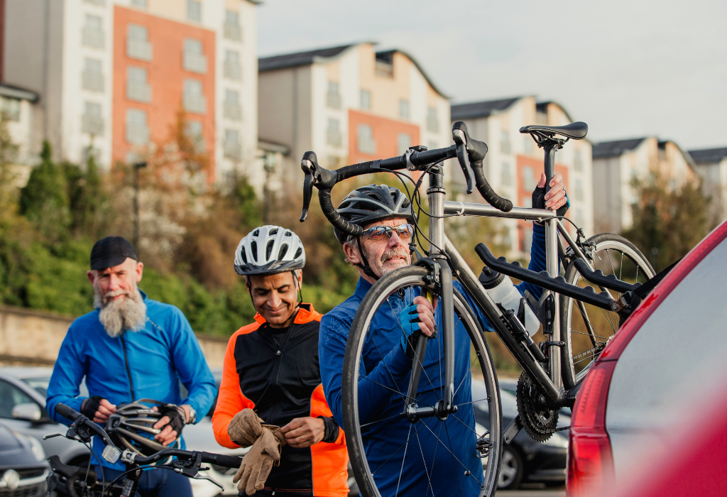 Cyclists placing a bike onto a bike rack on a vehicle